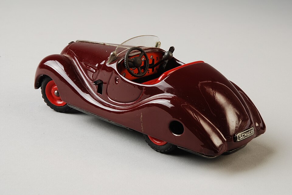 Donkerrode opwindauto met ‘echte’ versnellingsbak in het dashboard, “Schuco Examico 4001”, met originele doos en handleiding, objectnr 66028-A-D(1), a model car by Schuco