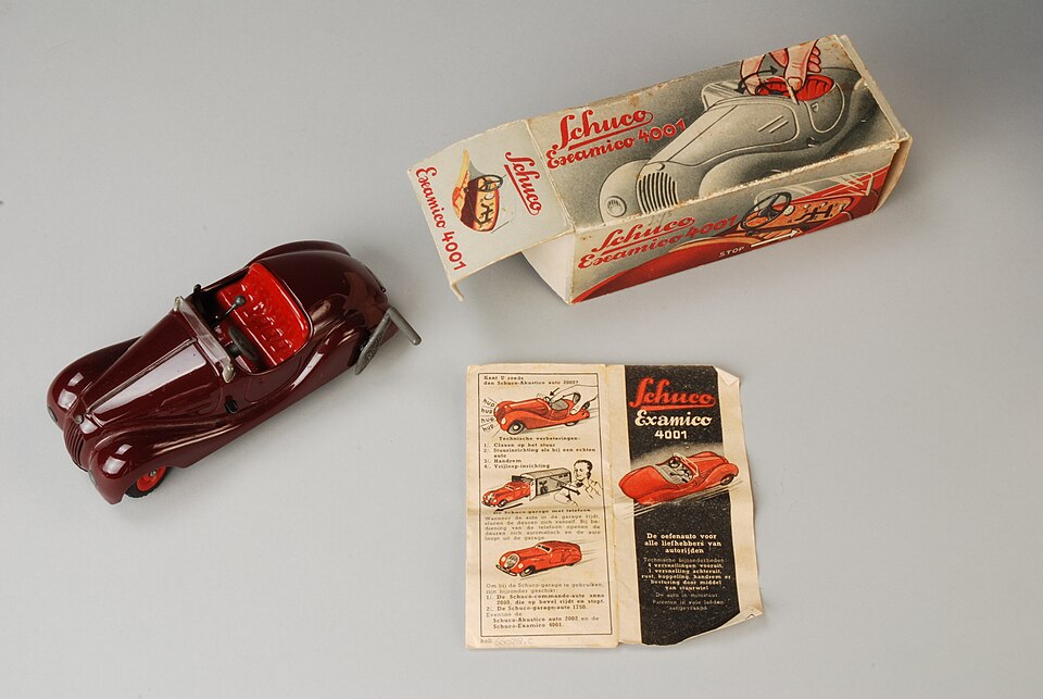 Donkerrode opwindauto met ‘echte’ versnellingsbak in het dashboard, “Schuco Examico 4001”, met originele doos en handleiding, objectnr 66028-A-D(2), a model car by Schuco